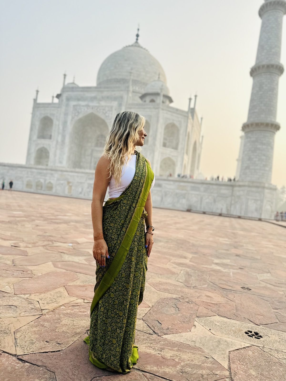 Olga con un sari verde frente al Taj Mahal, en India